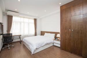 um quarto com uma cama, uma secretária e um armário em Sumitomo1 serviced apartment & hotel em Hanói