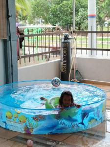 班台的住宿－Rumah singgah Haida，一个小女孩在水上公园的游泳池里游泳