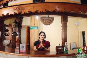 a woman standing behind a counter in front of a mirror at Dulcify cottage sarangkot in Pokhara