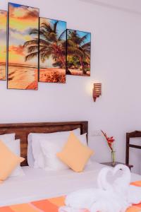 a bedroom with a bed with palm trees canvas wall art at Scenery River Star Hotel in Hikkaduwa