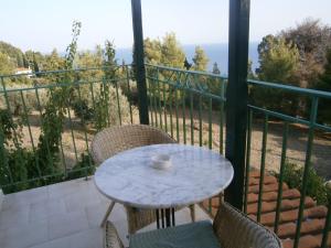 a table and chairs on a balcony with a view of the ocean at Pelagos in Stafylos
