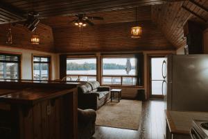 a living room with a couch and a refrigerator at Lang Lake Resort in Espanola