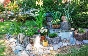 un giardino con fiori e piante su tronchi di Gorgeous Home In Zalewo With Lake View a Boreczno Altre 9 foto