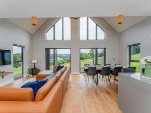 a living room with a couch and a table with chairs at Coed Y Pentre in Carno