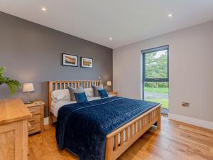 a bedroom with a large bed and a window at Coed Y Pentre in Carno