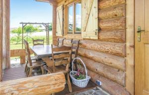 a wooden cabin with a table and chairs on a porch at 4 Bedroom Nice Home In Nidzica in Nidzica
