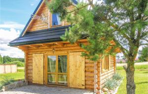 a log cabin with a large door and a tree at Nice Home In Nidzica With 4 Bedrooms And Outdoor Swimming Pool in Nidzica