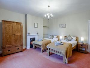 1 dormitorio con 2 camas y chimenea en Old Upper Gwestydd, en Highgate