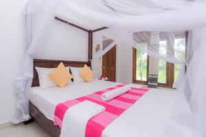 a bedroom with a bed with a striped blanket on it at Scenery River Star Hotel in Hikkaduwa