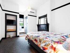 um quarto com uma cama com um cobertor colorido em Historic Pub Accommodation- En-suites - Shared Bathroom Double Rooms - Shared Bathroom Twins em Portland
