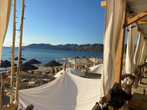 a hammock on a beach next to the ocean at Concas Apartaments in Portoscuso