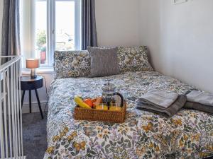 uma cesta de frutas numa cama num quarto em La Casita em Herne Bay