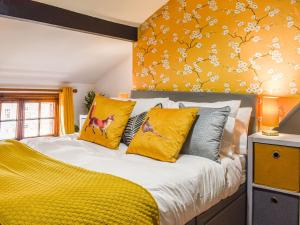 a bedroom with a bed with yellow pillows at Stonesthrow Townhouse in Leek
