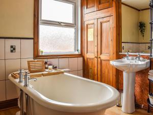 a bathroom with a large tub and a sink at Stonesthrow Townhouse in Leek