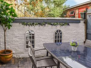 a patio with a table and chairs and a building at Stonesthrow Townhouse in Leek