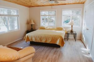 a bedroom with a bed and two windows at Lang Lake Resort in Espanola