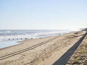 a beach with footprints in the sand and the ocean at Becleigh-daisy in Bacton