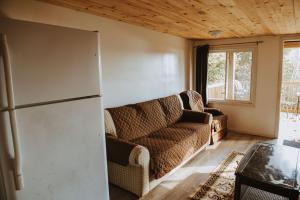 a living room with a couch and a refrigerator at Lang Lake Resort in Espanola