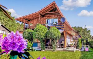una casa de madera con un patio con flores púrpuras en 5 Bedroom Pet Friendly Home In Rowy, en Rowy