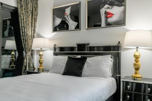 a bedroom with a bed with two lamps and two pictures on the wall at The Celebrity in Auckland