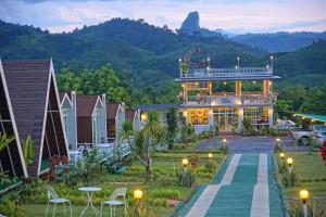 a view of a house with a mountain in the background at Khao Sok 99 Camp and Cafe in Khao Sok