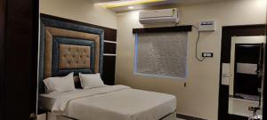 um quarto de hotel com uma cama e uma televisão em KS PAYING GUEST HOUSE em Varanasi