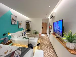 a bedroom with two beds and a flat screen tv at Apple 1 Hotel Queensbay in Bayan Lepas