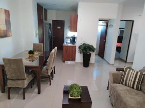 マサトランにあるDepartamento a 200 Mts de la playa y alberca en planta bajaのテーブルと椅子のあるダイニングルームとリビングルーム