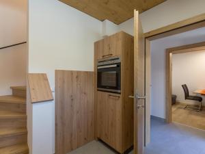 una piccola cucina con armadio in legno e piano cottura di Appartement Stephanie a Going