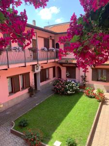 un edificio rosa con un patio con flores en La Corte Albergo, en Desio