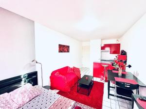 a living room with a red couch and a table at Le Red Escape à 15min du centre avec parking privé gratuit in Annecy