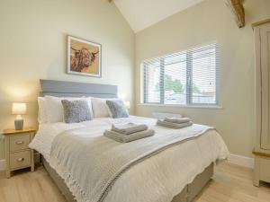 a bedroom with a large bed with towels on it at The Oak in Wingfield