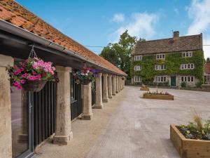 a courtyard of an old building with flower baskets at The Oak in Wingfield