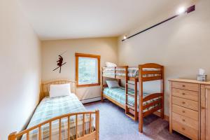 a bedroom with two bunk beds and a window at Butte Bliss in Ludlow