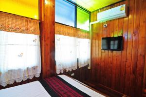 a small room with a bed and a tv at Kaloang home in Bangkok