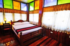 a bed in a room with stained glass windows at Kaloang home in Bangkok