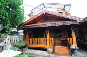 drewniany dom z werandą i balkonem w obiekcie Kaloang home w mieście Bangkok