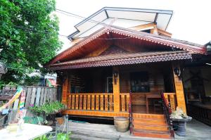 a wooden house with a porch and a balcony at Kaloang home in Bangkok