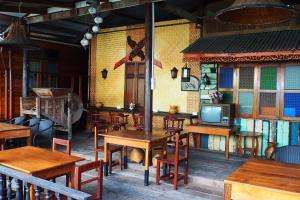 un restaurante con mesas de madera y TV en la pared en Kaloang home, en Bangkok