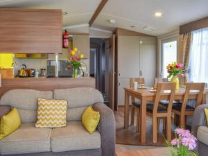 ein Wohnzimmer und eine Küche mit einem Sofa und einem Tisch in der Unterkunft Little Bodieve in Wadebridge