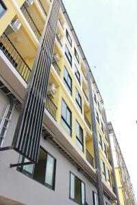 a yellow and white building with a fire escape at Artada Residence in Ban Laem Chabang