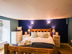1 dormitorio con 1 cama grande y pared azul en Glasfor, en Llwyngwril