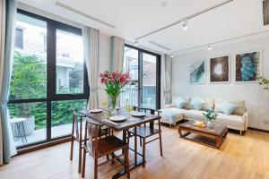 a living room with a table and a couch at Margaery Boutique Apartment & Skyon9 Rooftop Bar in Hanoi