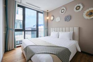 a bedroom with a large bed and a large window at Margaery Boutique Apartment & Skyon9 Rooftop Bar in Hanoi