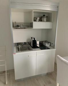 eine Küche mit weißen Schränken und einem Waschbecken in der Unterkunft Dolce Dormire Suite in Arcola