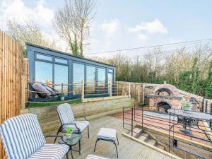 a patio with two chairs and a fireplace at Riverview Lodge - Uk36550 in Ashleworth