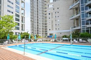 an outdoor swimming pool with buildings in the background at Mountain Vision by HolyGuest in Tel Aviv