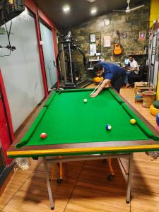 a man playing pool on a pool table at Backpack Stay in Mumbai