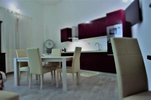 - une cuisine avec une table et des chaises blanches dans l'établissement A Su Mulinu - Locazione turistica, à Pozzomaggiore