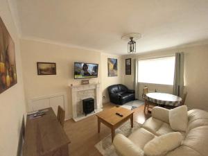 a living room with a couch and a fireplace at Private Lounge and Double Room in Kilwinning
